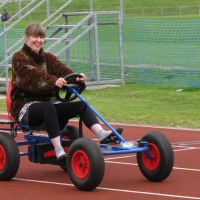 Female participant smiling while riding a go-kart